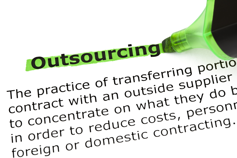 Definition of the word Outsourcing, highlighted in green with felt tip pen.